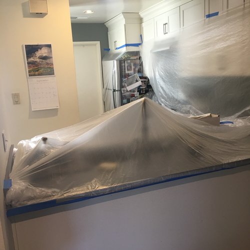 Kitchen protected with plastic during water damage wall repairs