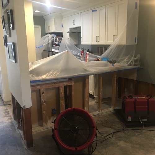 Kitchen wall framing exposed with cabinets covered during rebuild